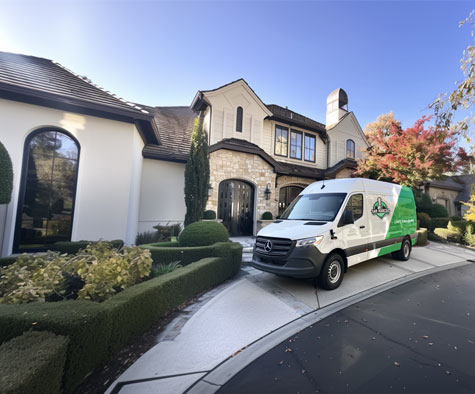 San Marcos Drywall Repair Logo on a work van outside of a high-end home